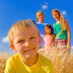 Kinder im Weizenfeld beim Urlaub auf dem Bauernhof